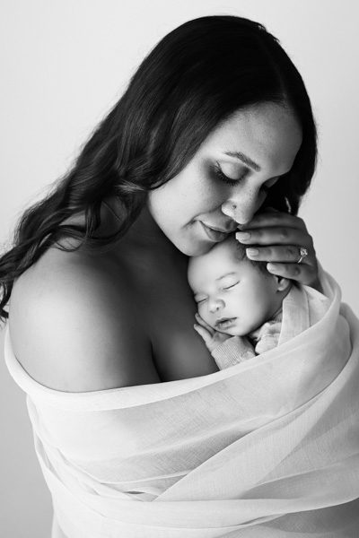Newborn baby wrapped in layered textiles